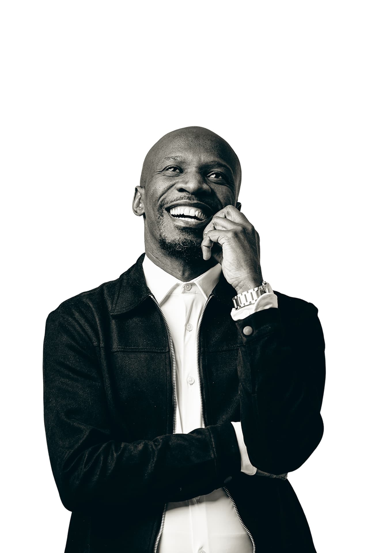 Black and white portrait of Teekay Netshideyi laughing, hand resting on his chin